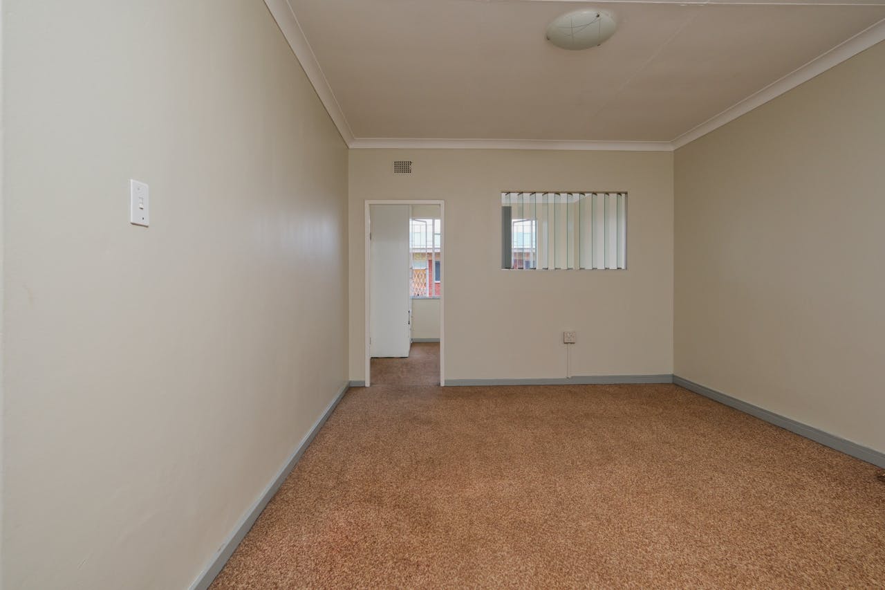 Spacious empty room featuring carpet flooring and neutral walls. Ideal for real estate listings.